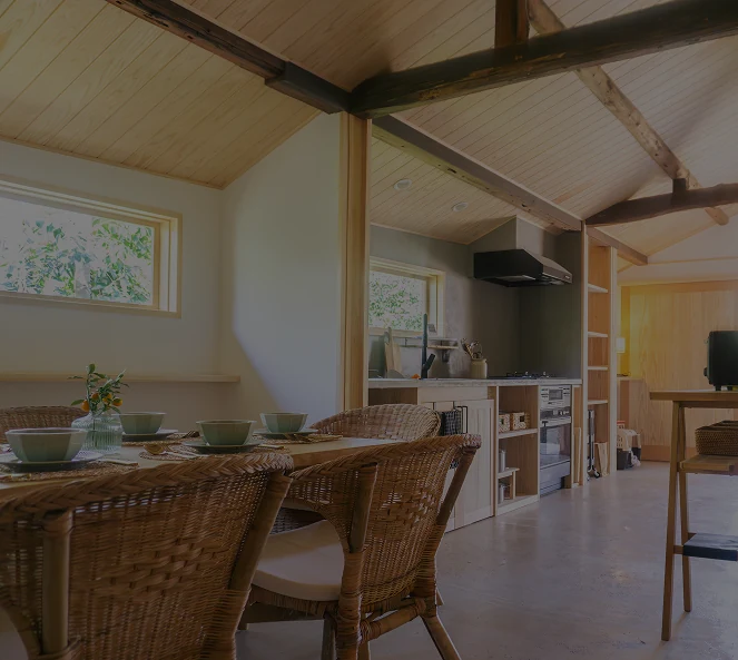 Tea House interior — restored beams, rattan chairs and a modern kitchen