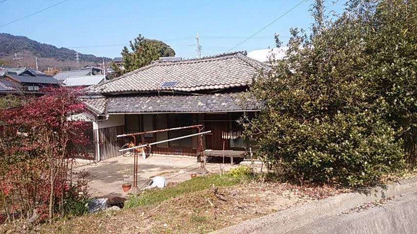 The house seen from across the road, deep eaves shading the veranda